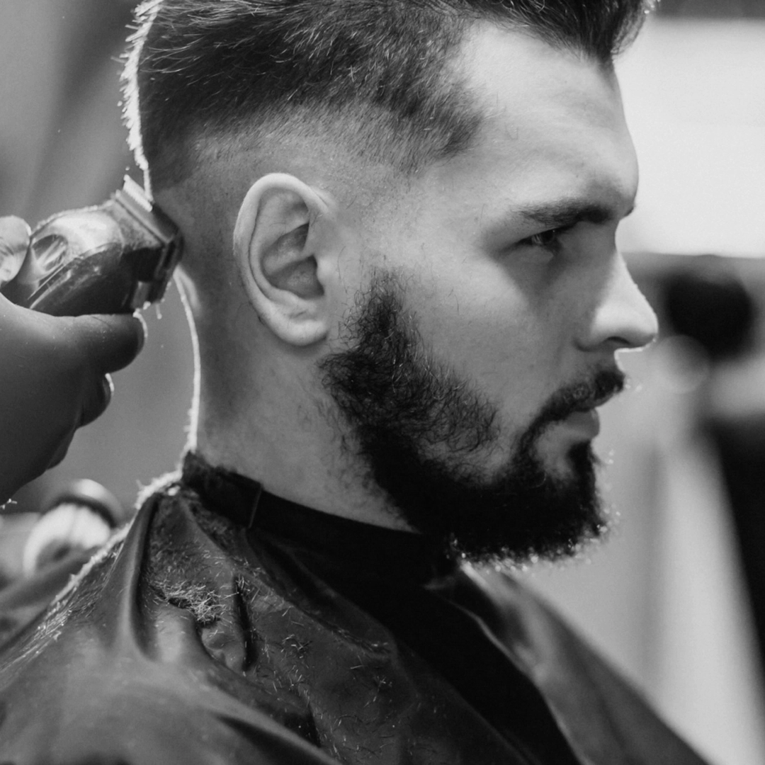 Barber refining a skin fade with clippers